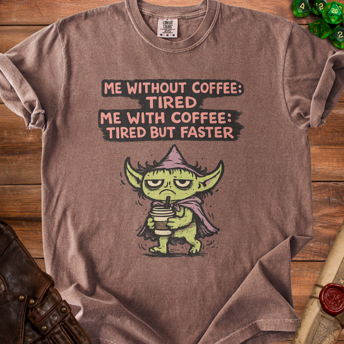 Brown t-shirt with a grumpy green character holding coffee and text.