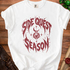White t-shirt with "Side Quest Season" text and D20 dice design.