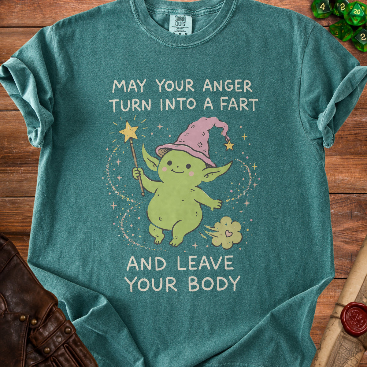 Teal t-shirt with cartoon creature and text "May your anger turn into a fart and leave your body."