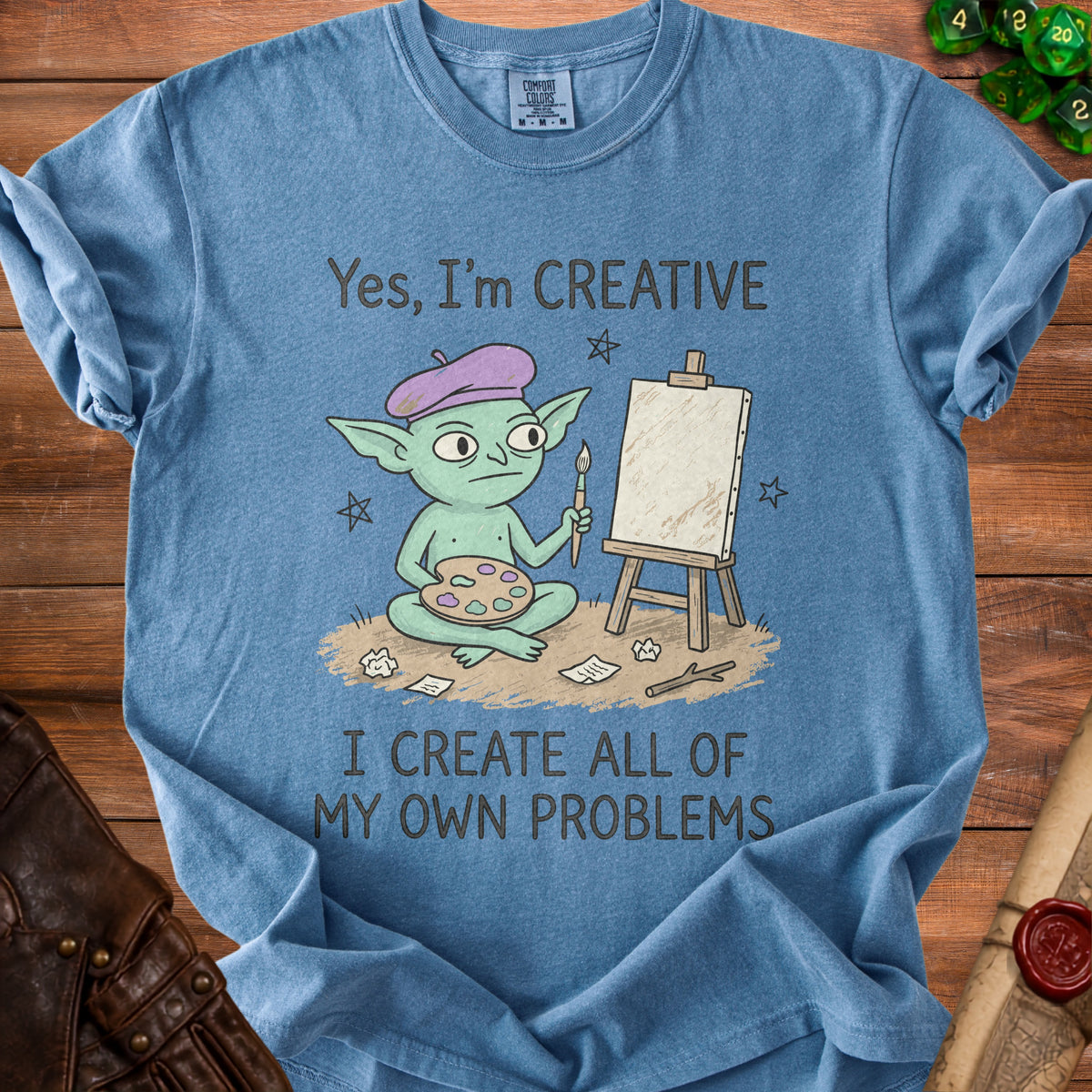 Blue t-shirt with a cartoon goblin artist and the text "Yes, I'm CREATIVE I CREATE ALL OF MY OWN PROBLEMS."
