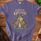 Purple t-shirt with frog in wizard hat on mushroom, "Touch Grass" and "But Make It Magical" text.