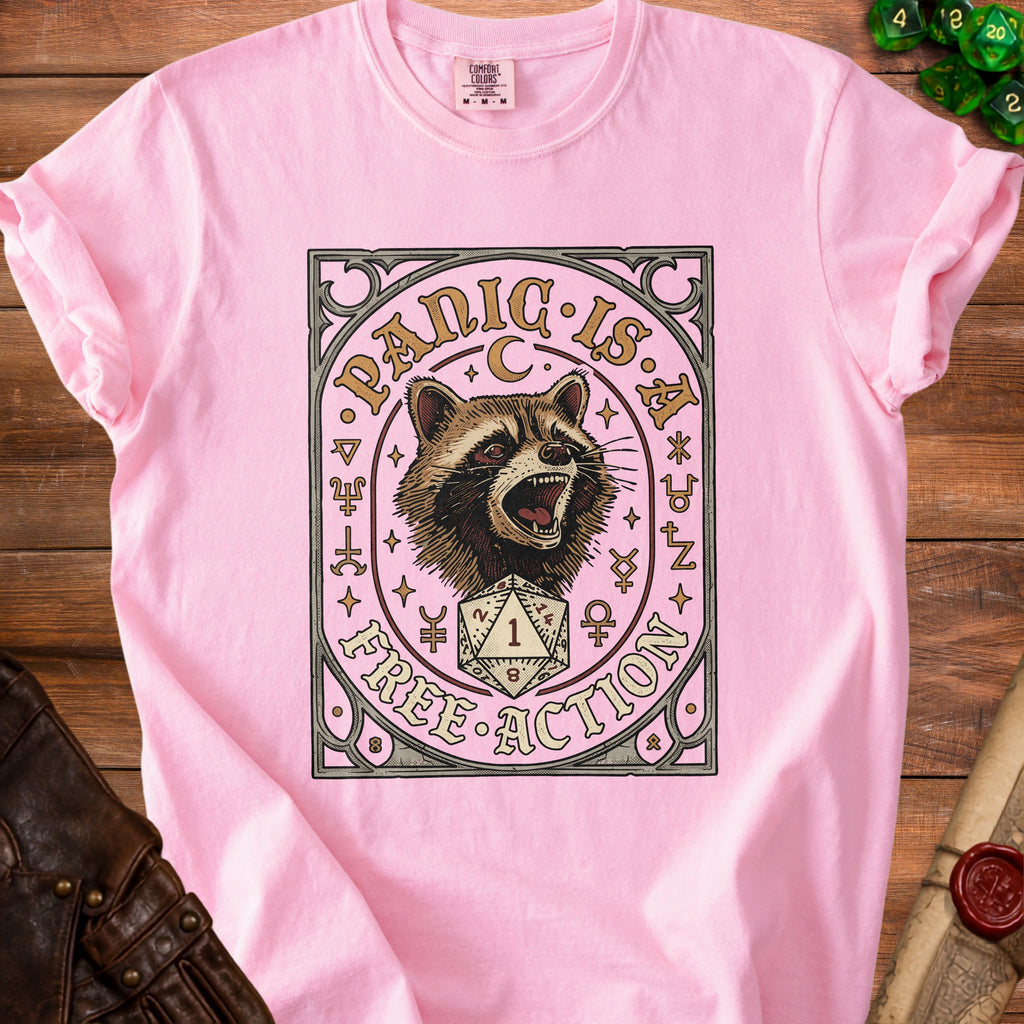 Pink t-shirt with a distressed graphic of a raccoon, dice, and the text "Panic is a free action".