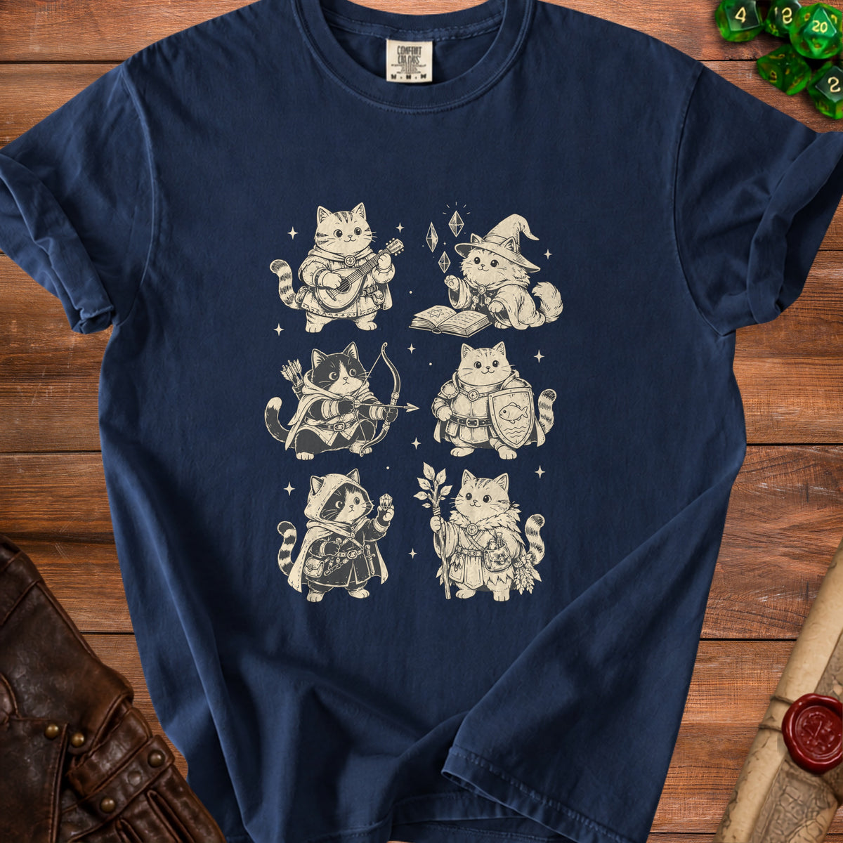 Six illustrated cats dressed as fantasy characters on a dark blue t-shirt.