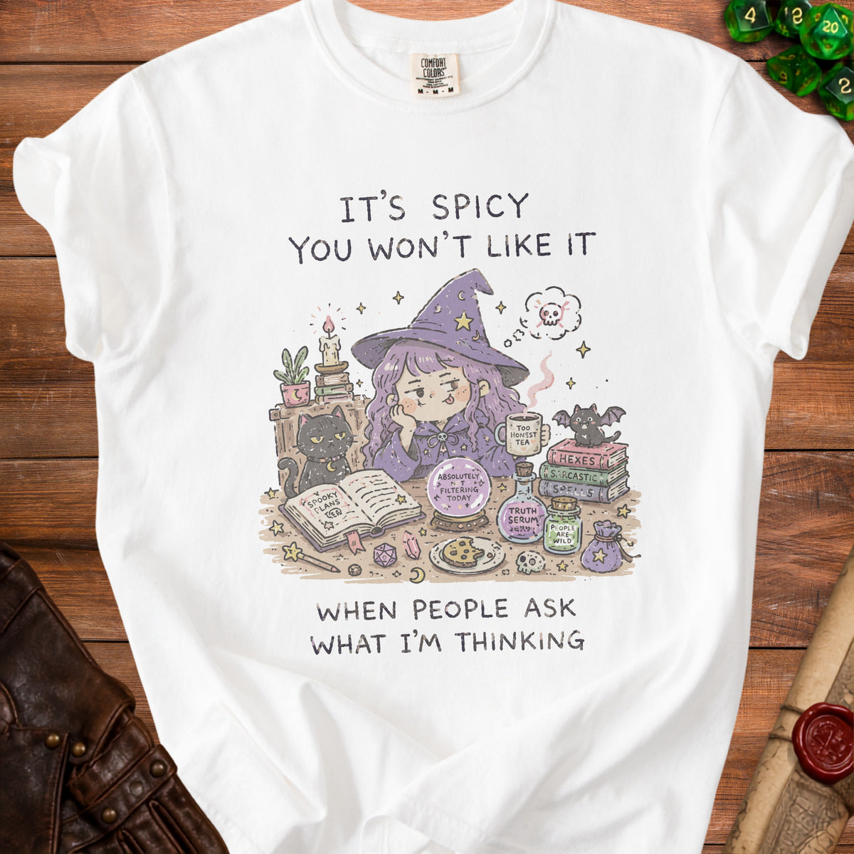 White t-shirt with illustration of a witch and witchy items, text reads "It's Spicy You Won't Like It When People Ask What I'm Thinking."