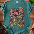 Goblin Hours graphic t-shirt with goblin, frog, books, and treasure.