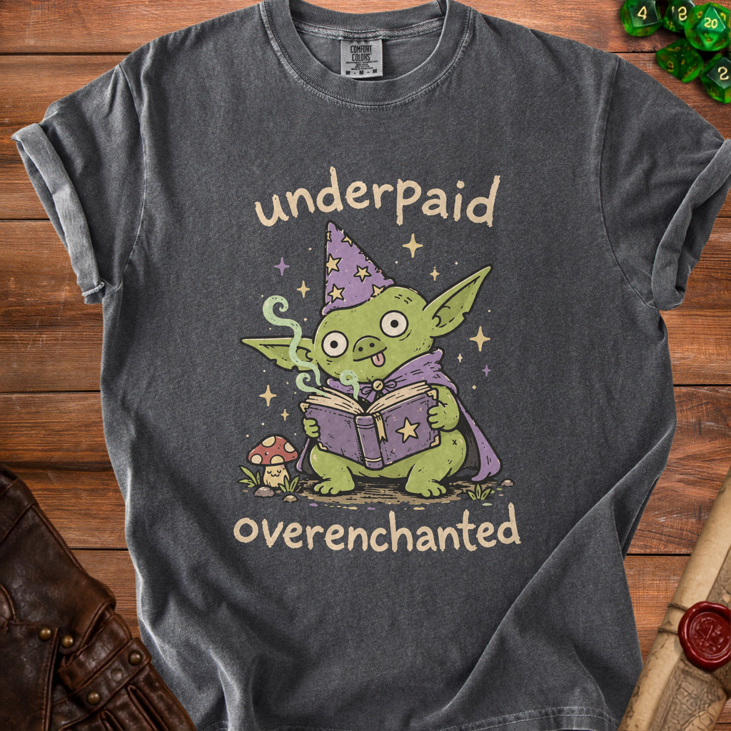 Charcoal t-shirt with a green goblin reading a book, text says "underpaid overenchanted."