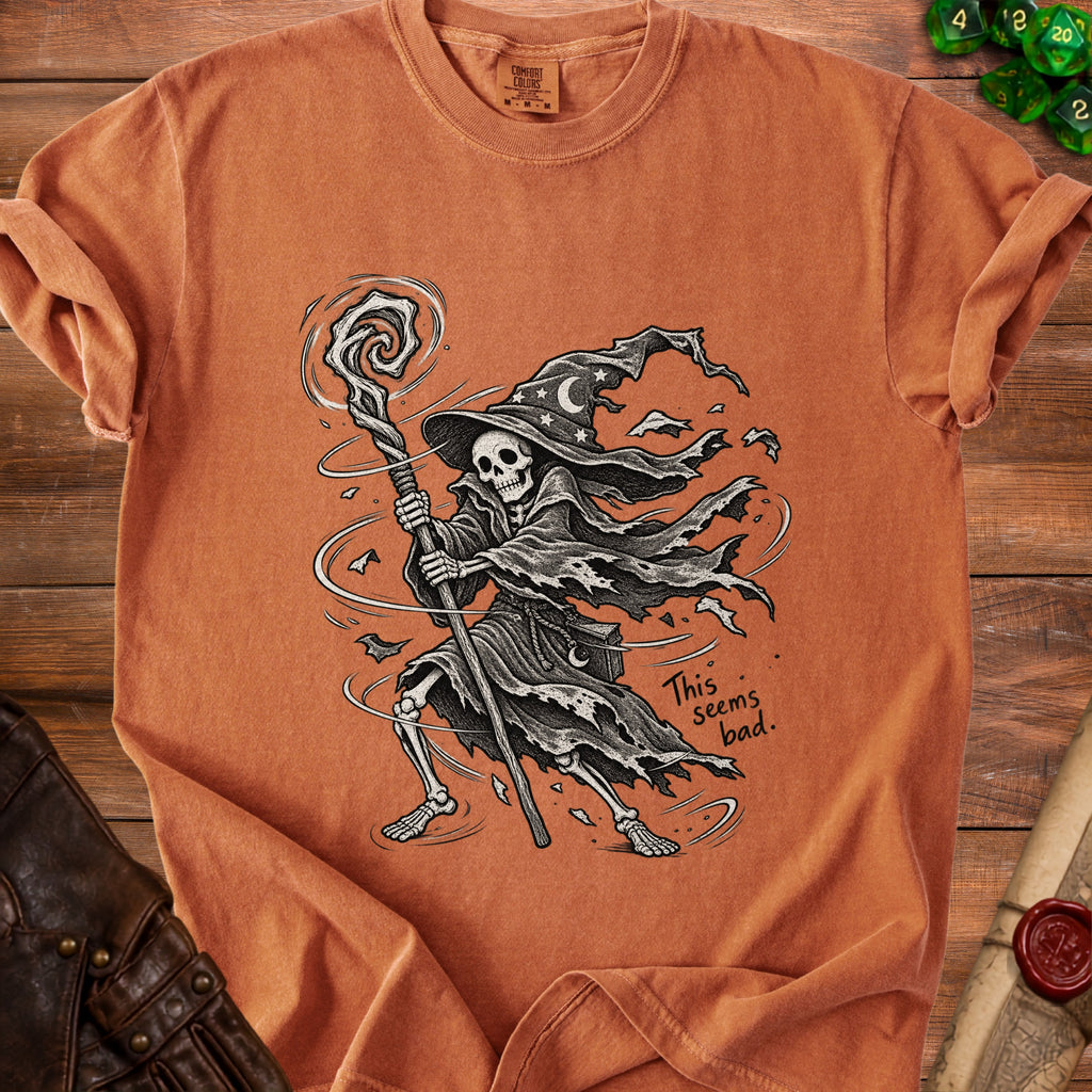 Skeleton wizard graphic on an orange t-shirt with text "This seems bad."