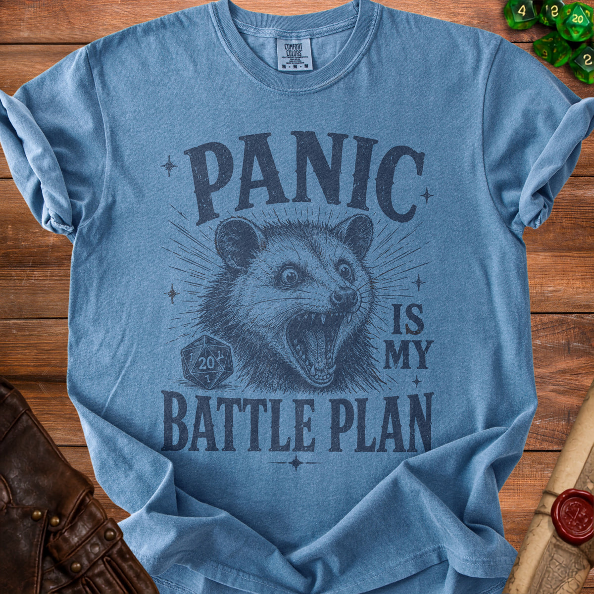 Blue t-shirt with a distressed print of a possum and text "PANIC IS MY BATTLE PLAN".