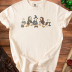 Cream t-shirt with a printed illustration of five ducks in fantasy adventurer attire sitting around a campfire.