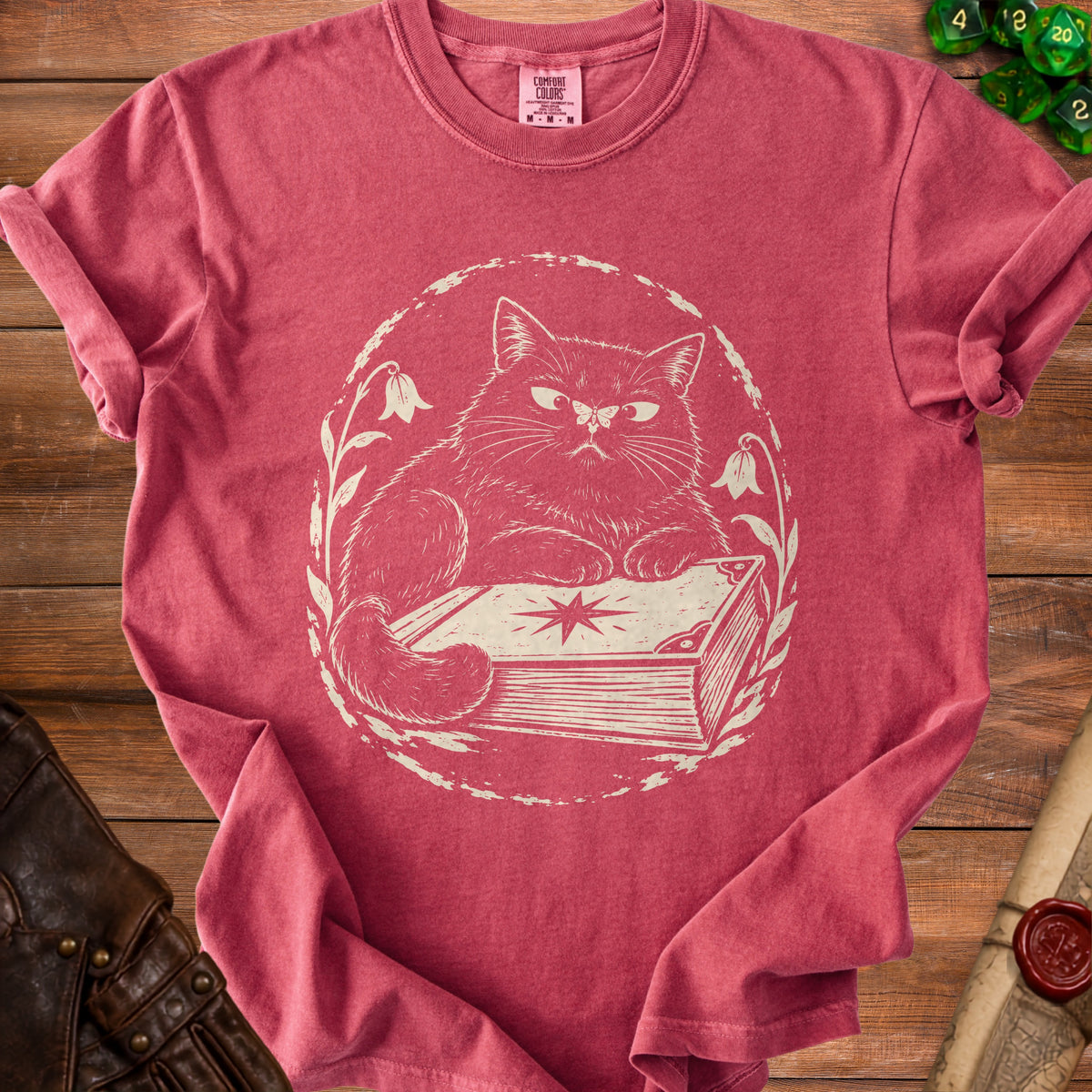 Red t-shirt with a cream-colored print of a fluffy cat sitting on a book.