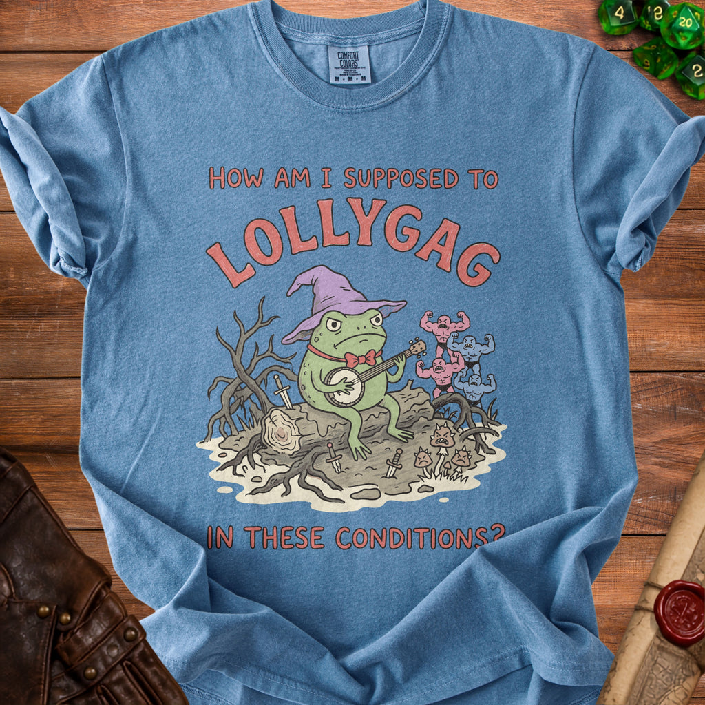 Blue t-shirt with a cartoon frog wearing a witch hat playing a banjo.