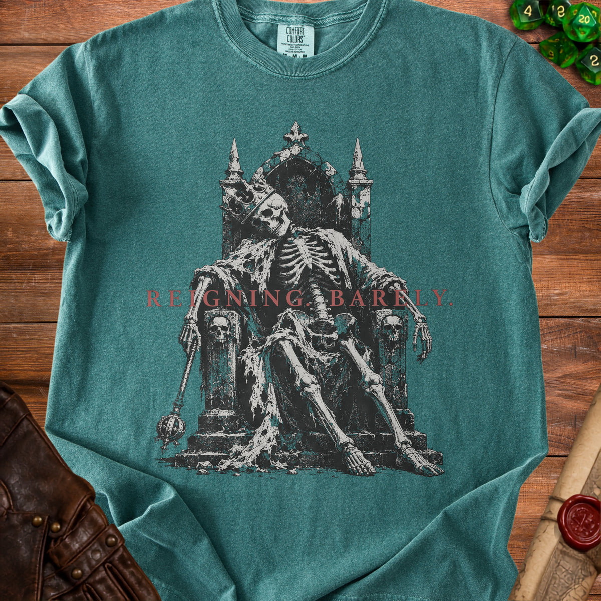 Skeleton king on throne with crown and scepter, "REIGNING BARELY" text.