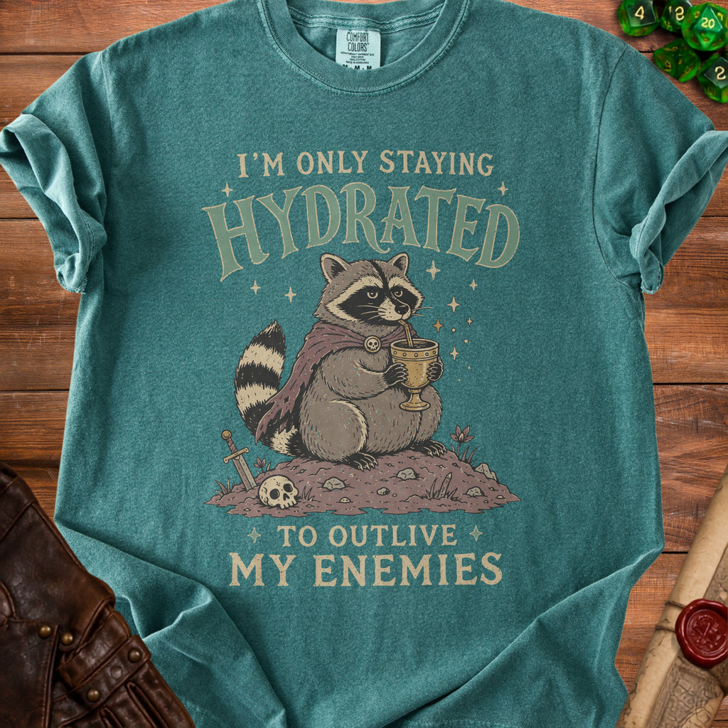Teal t-shirt with a raccoon drinking from a goblet, stating "I'm only staying hydrated to outlive my enemies".