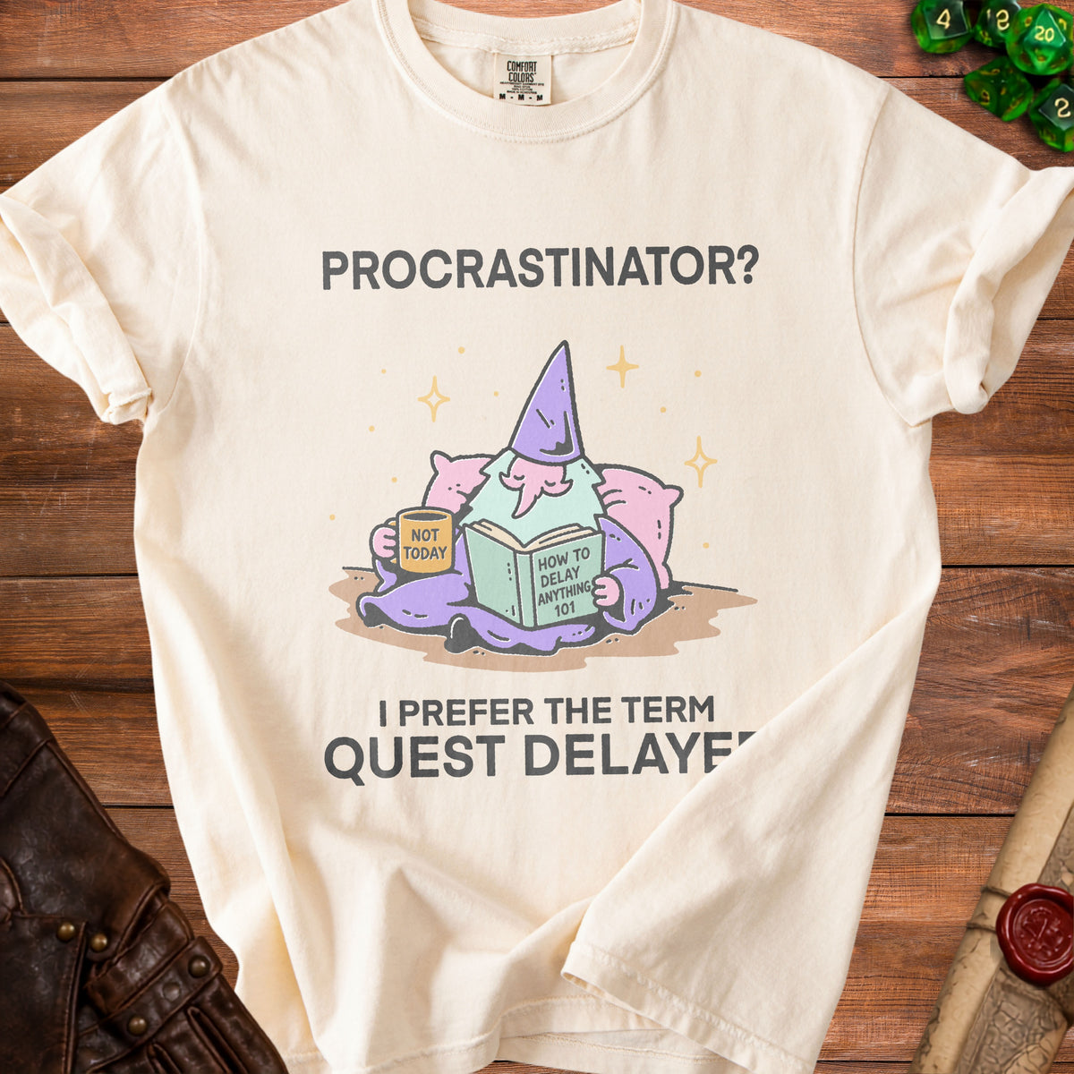 Cream t-shirt with gnome reading "How to Delay Anything 101."