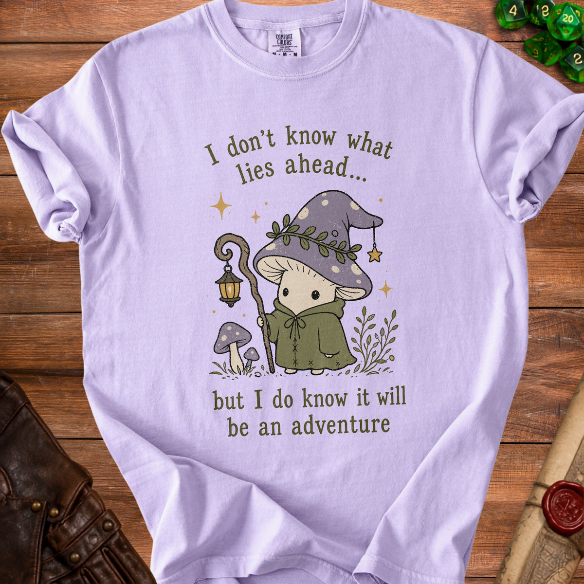 Lilac t-shirt with cartoon mushroom wizard and text about adventure.
