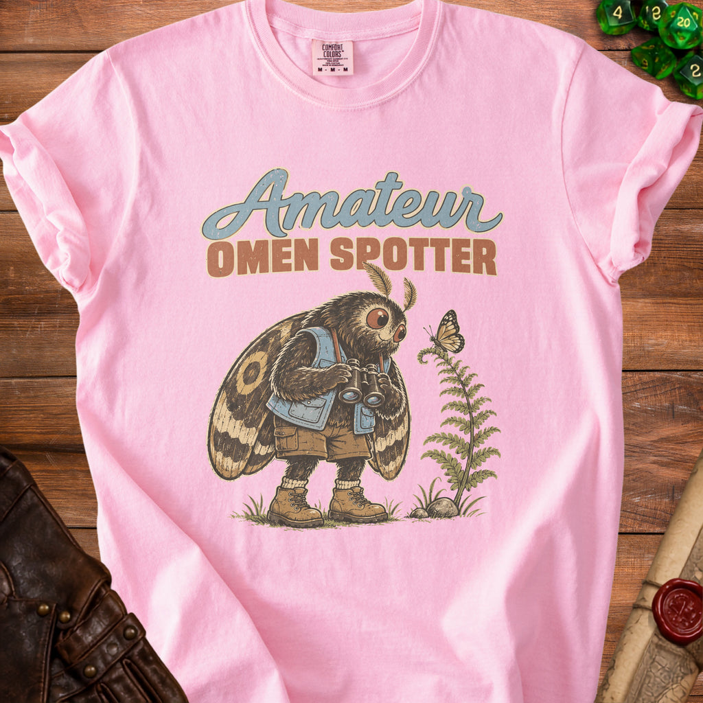 Pink t-shirt with "Amateur Omen Spotter" text and a moth character holding binoculars.