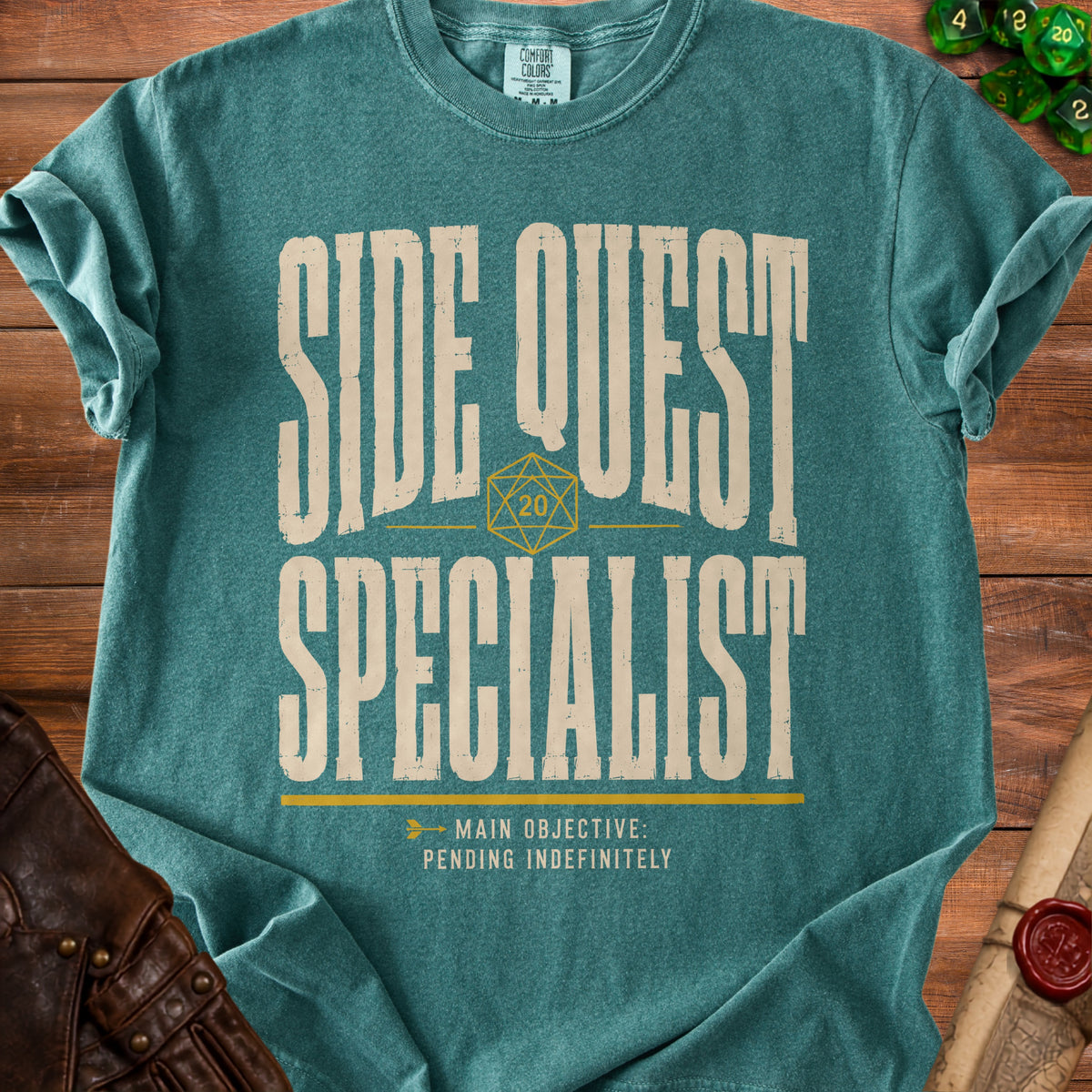 Teal t-shirt with "SIDE QUEST SPECIALIST" and "MAIN OBJECTIVE: PENDING INDEFINITELY" text.