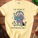 Yellow t-shirt with illustration of a wizard reading an "Existential Tome" and text "The Sound of Existential Dream".