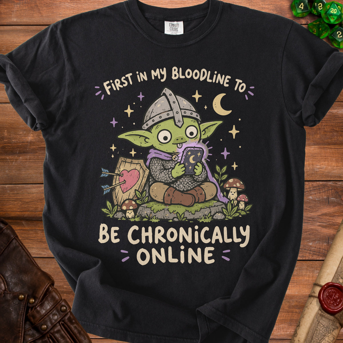 Black t-shirt with a cartoon goblin wearing a helmet and holding a phone, reading "First in my bloodline to be chronically online".