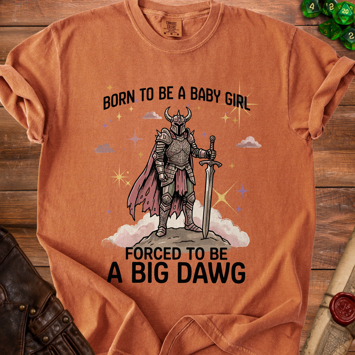 Orange t-shirt with text "Born to be a baby girl, forced to be a big dawg" and knight graphic.