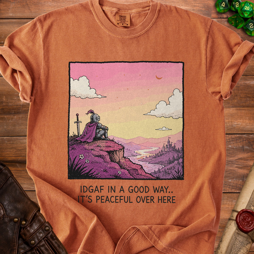 Orange t-shirt with a graphic of a knight looking at a landscape with text "IDGAF IN A GOOD WAY.. IT'S PEACEFUL OVER HERE".