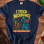 T-shirt graphic with yellow text "I Tried Necromancy" and skeletons.