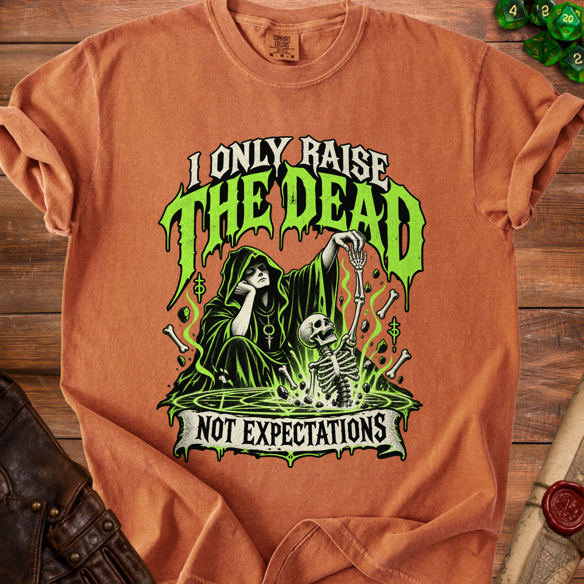 Orange t-shirt with "I Only Raise the Dead, Not Expectations" graphic.