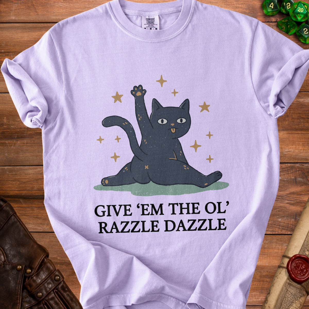 Lavender t-shirt with a graphic of a black cat and the text "GIVE 'EM THE OL' RAZZLE DAZZLE".