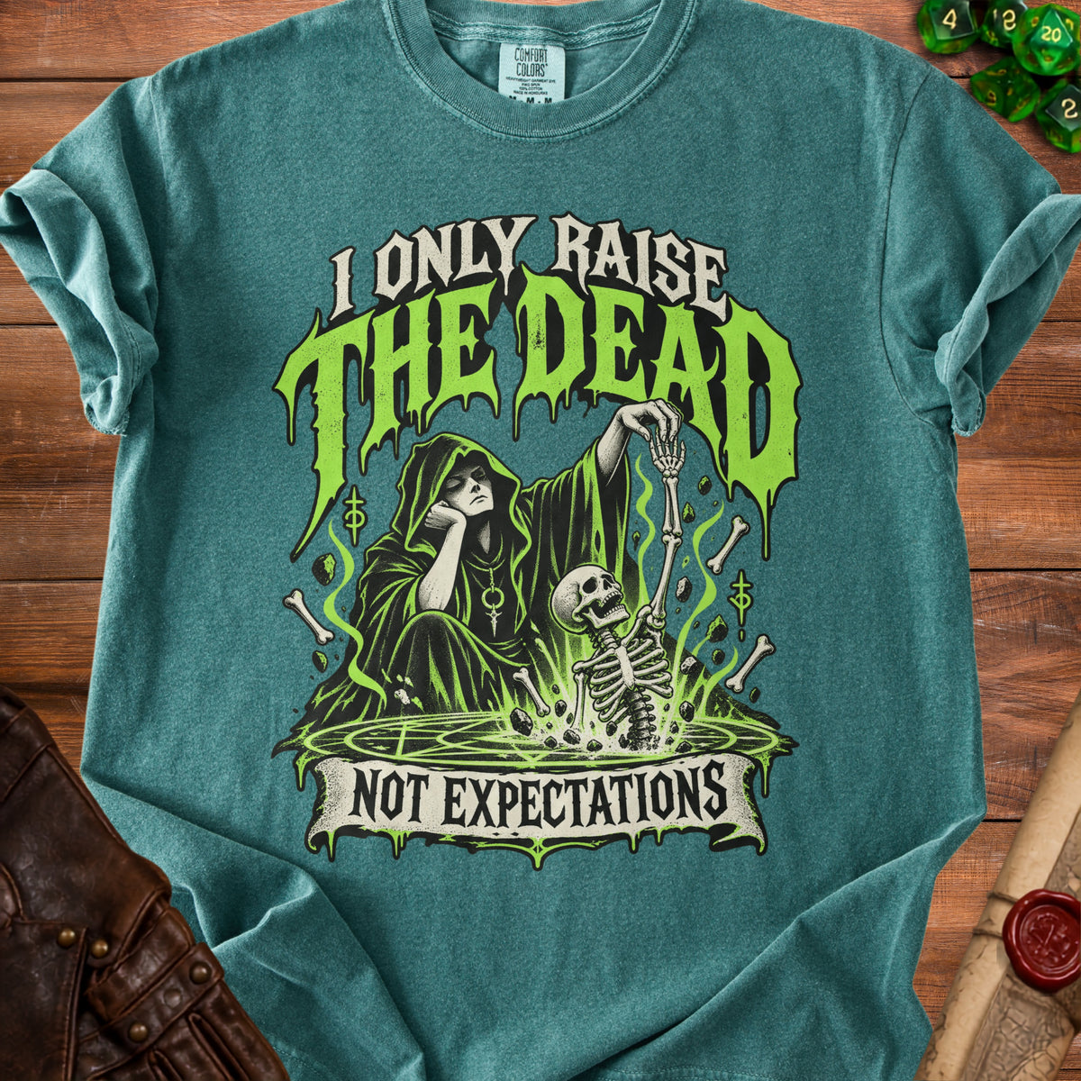 Teal shirt with graphic: Grim Reaper and skeleton, "I Only Raise The Dead Not Expectations".