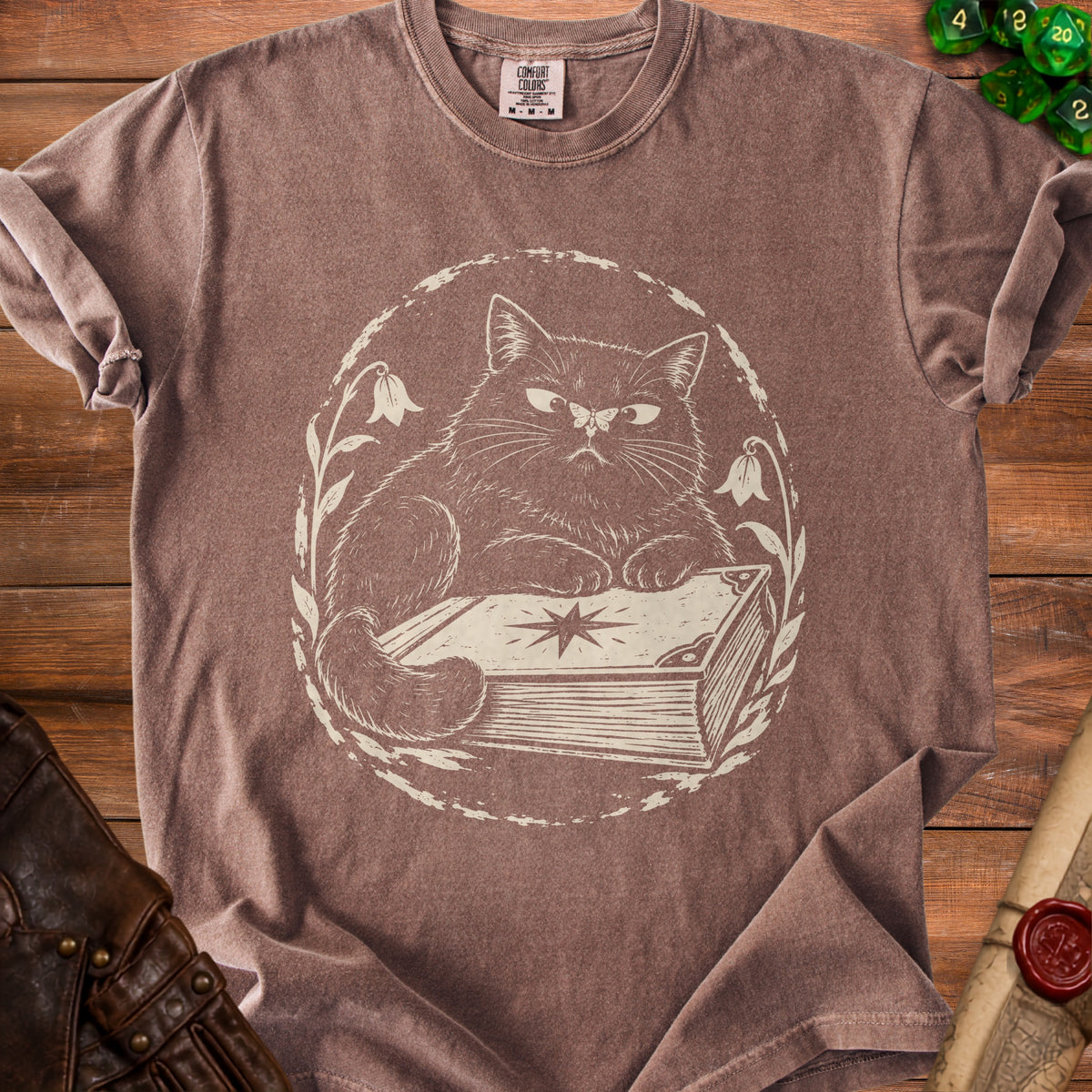 Brown t-shirt with a cream-colored line drawing of a cat resting on a book.
