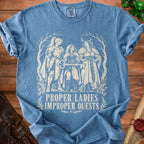 Blue t-shirt with "Proper Ladies Improper Quests" text and fantasy women illustration.