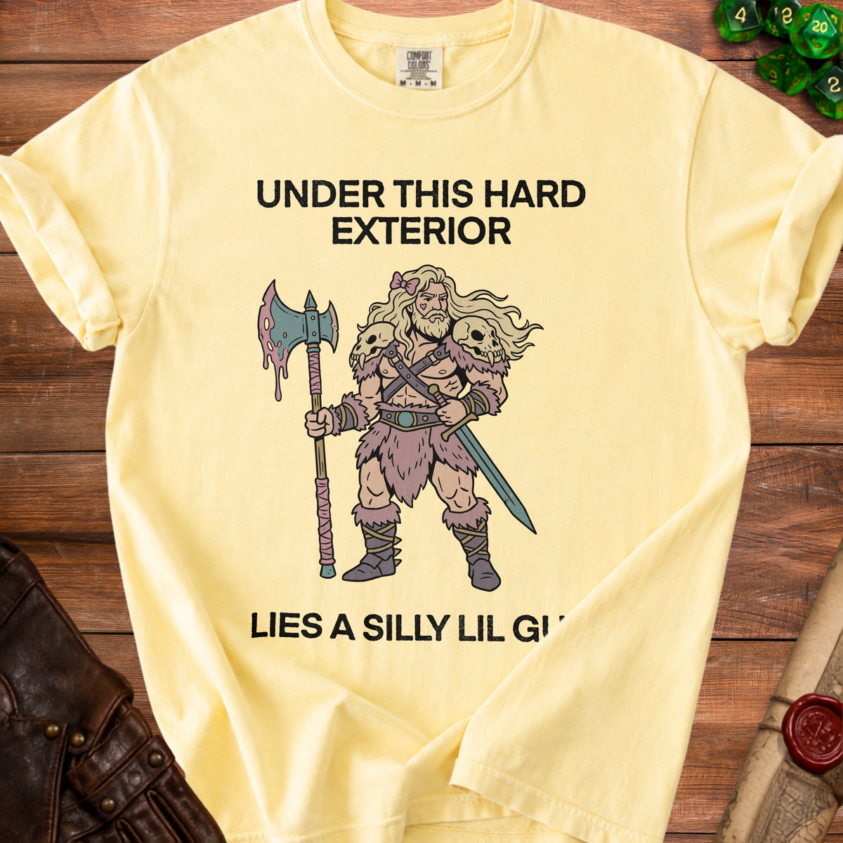 Yellow t-shirt with "UNDER THIS HARD EXTERIOR LIES A SILLY LIL GI" text and barbarian illustration.