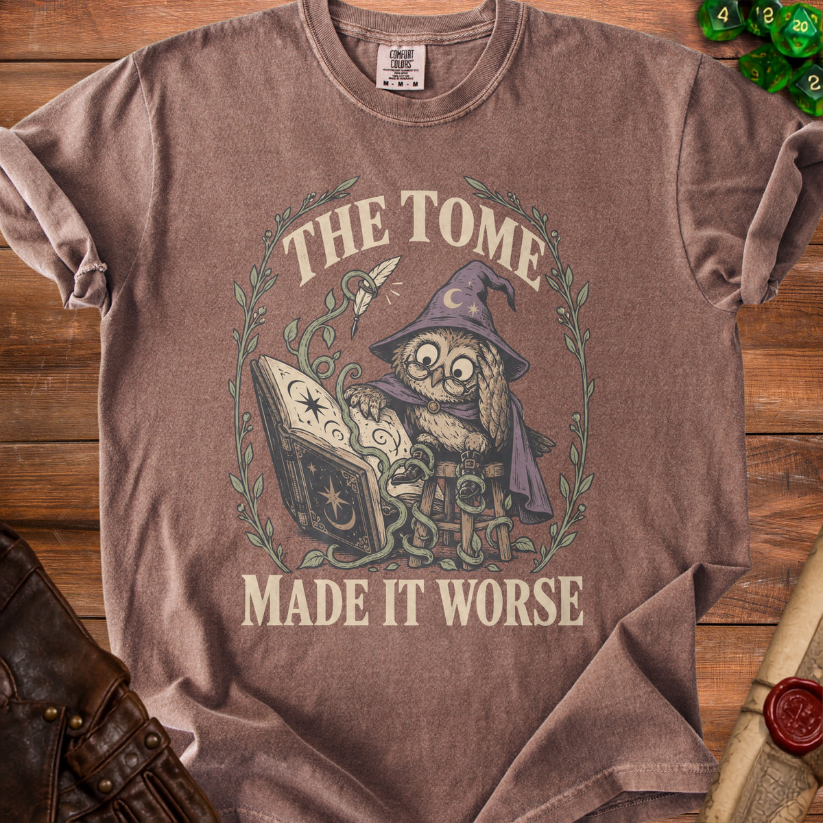 Brown t-shirt with graphic of an owl wizard reading a book and text "The Tome Made It Worse".