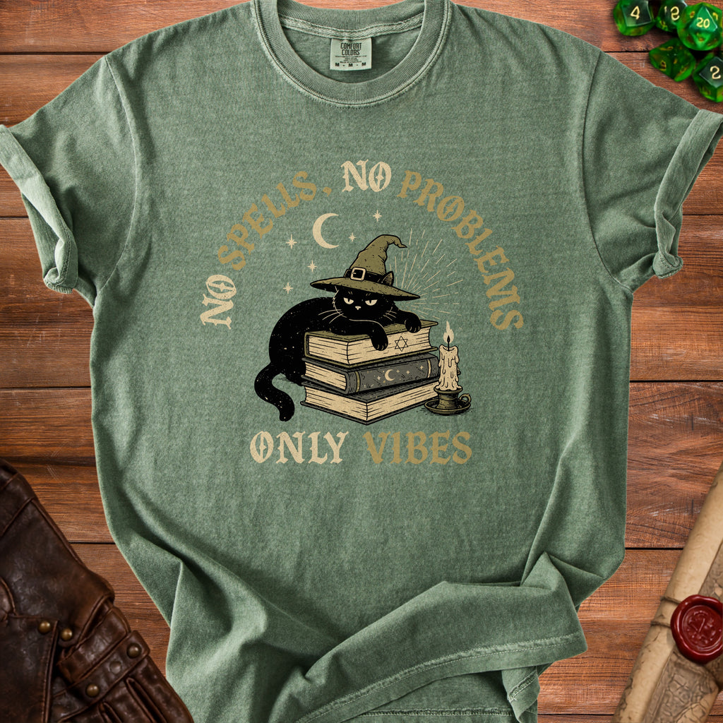 Green t-shirt with black cat wearing witch hat on books, text "No Spells. No Problems. Only Vibes."