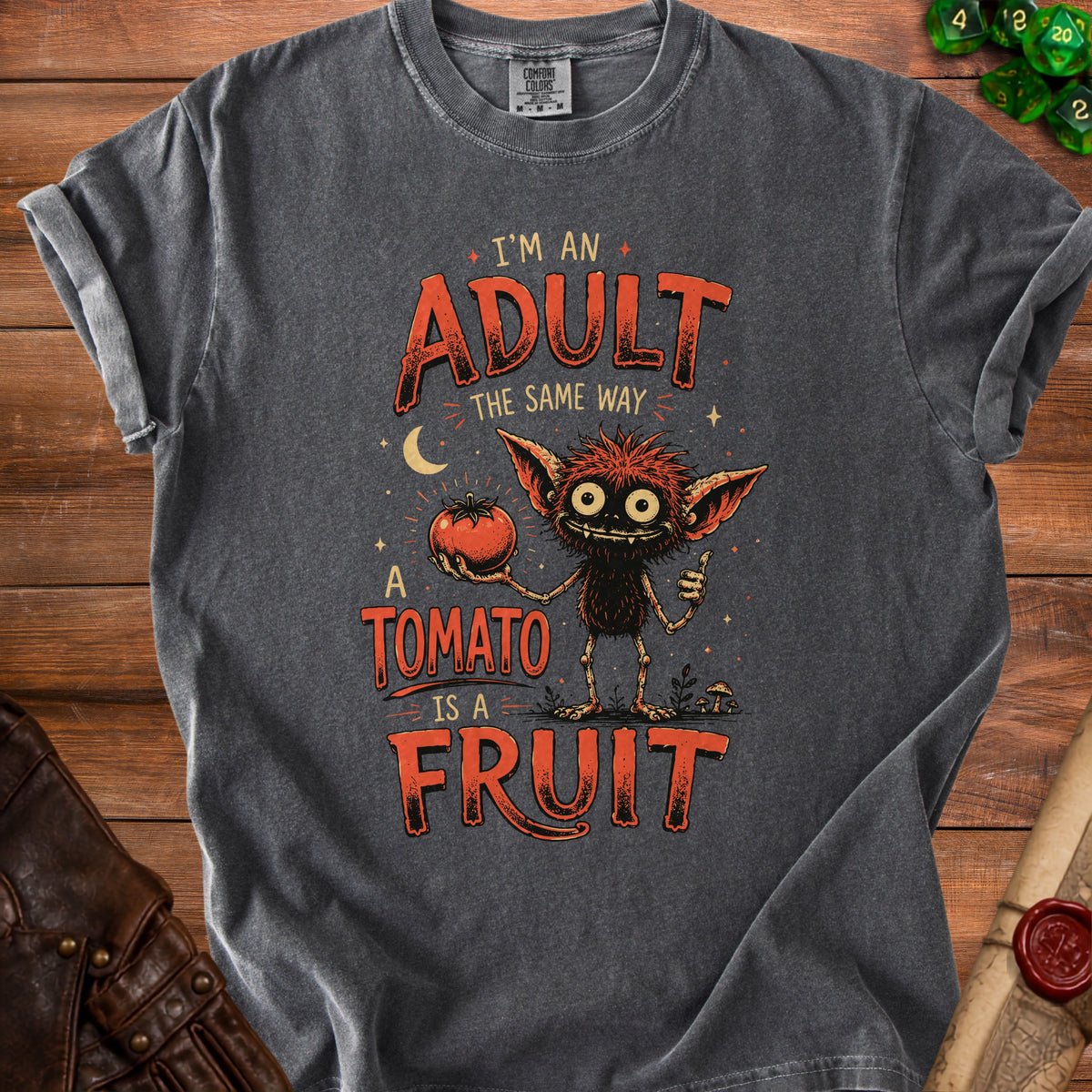 T-shirt with a creature holding a tomato and text "I'm an adult the same way a tomato is a fruit."