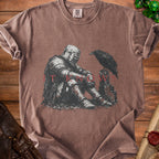 Brown t-shirt with distressed knight and raven graphic with text "IT KNOWS".