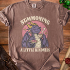 Purple dragon holding tea and cookies with text "Summoning a Little Kindness".