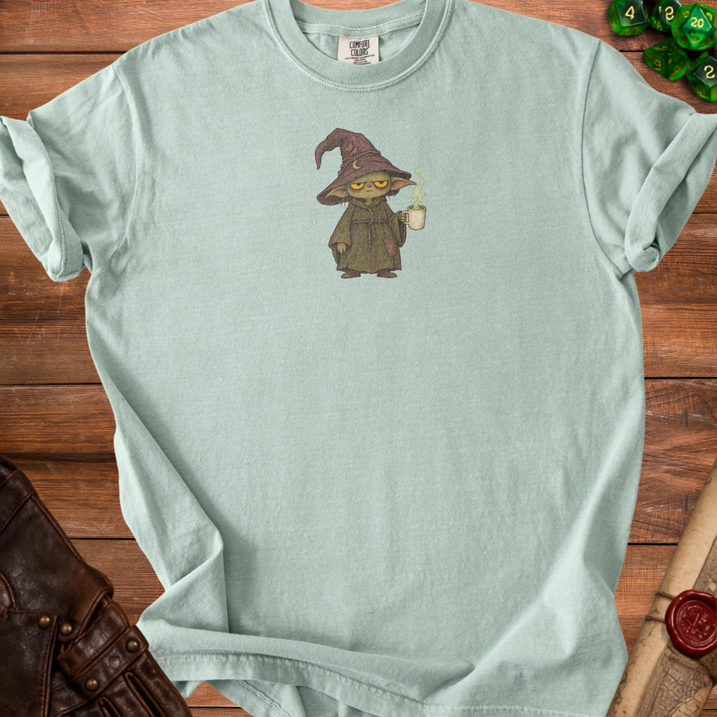 Mint green t-shirt with illustration of a small, grumpy wizard holding a steaming mug.