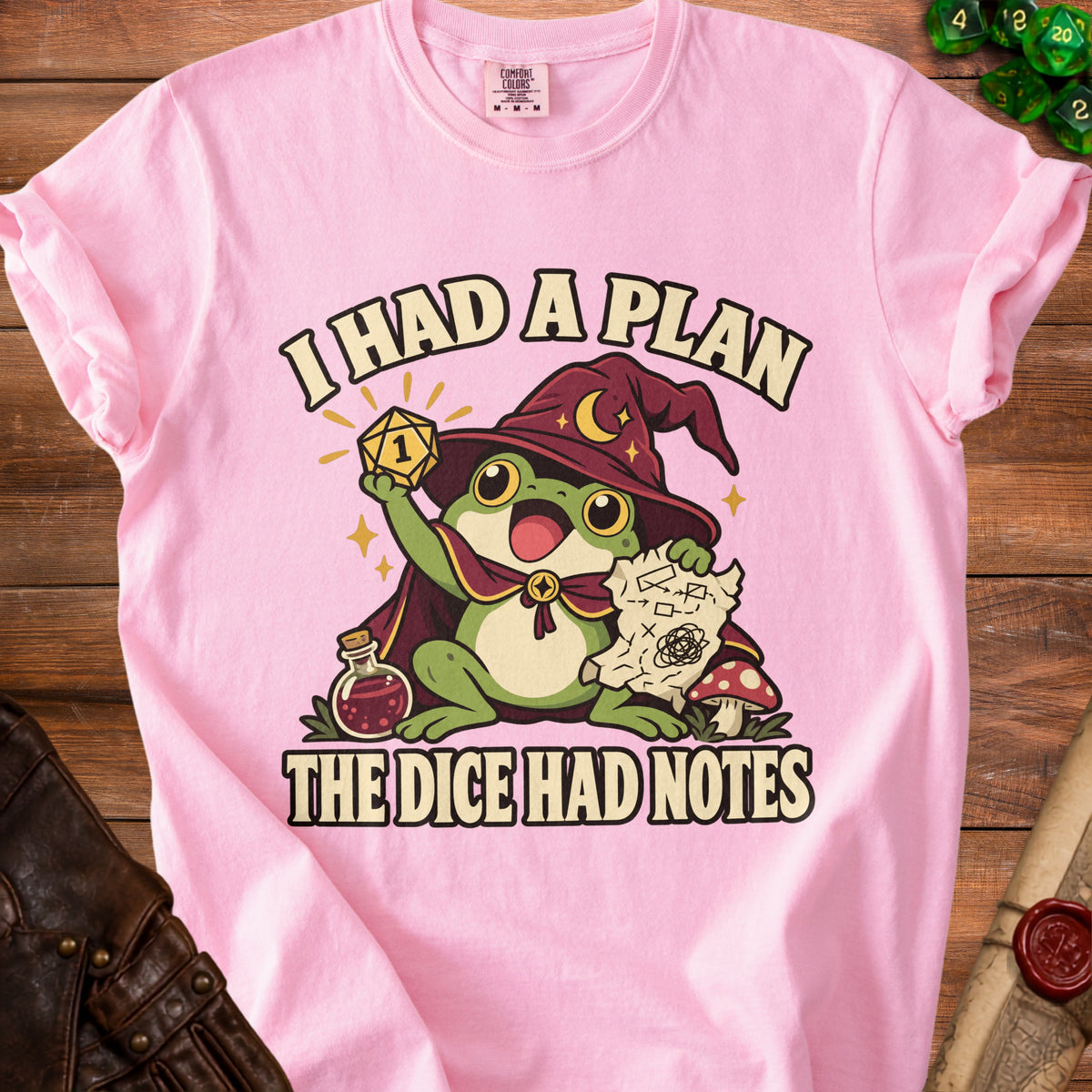 Pink t-shirt with a frog wizard graphic and text "I HAD A PLAN THE DICE HAD NOTES."