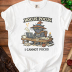 White t-shirt with "Hocus Pocus I Cannot Focus" text and a cat wizard graphic.
