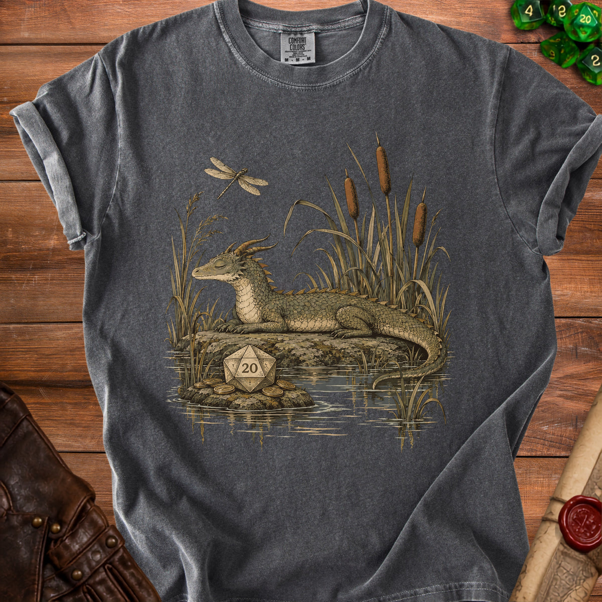 T-shirt graphic: dragon by water with a D20 die and coins.