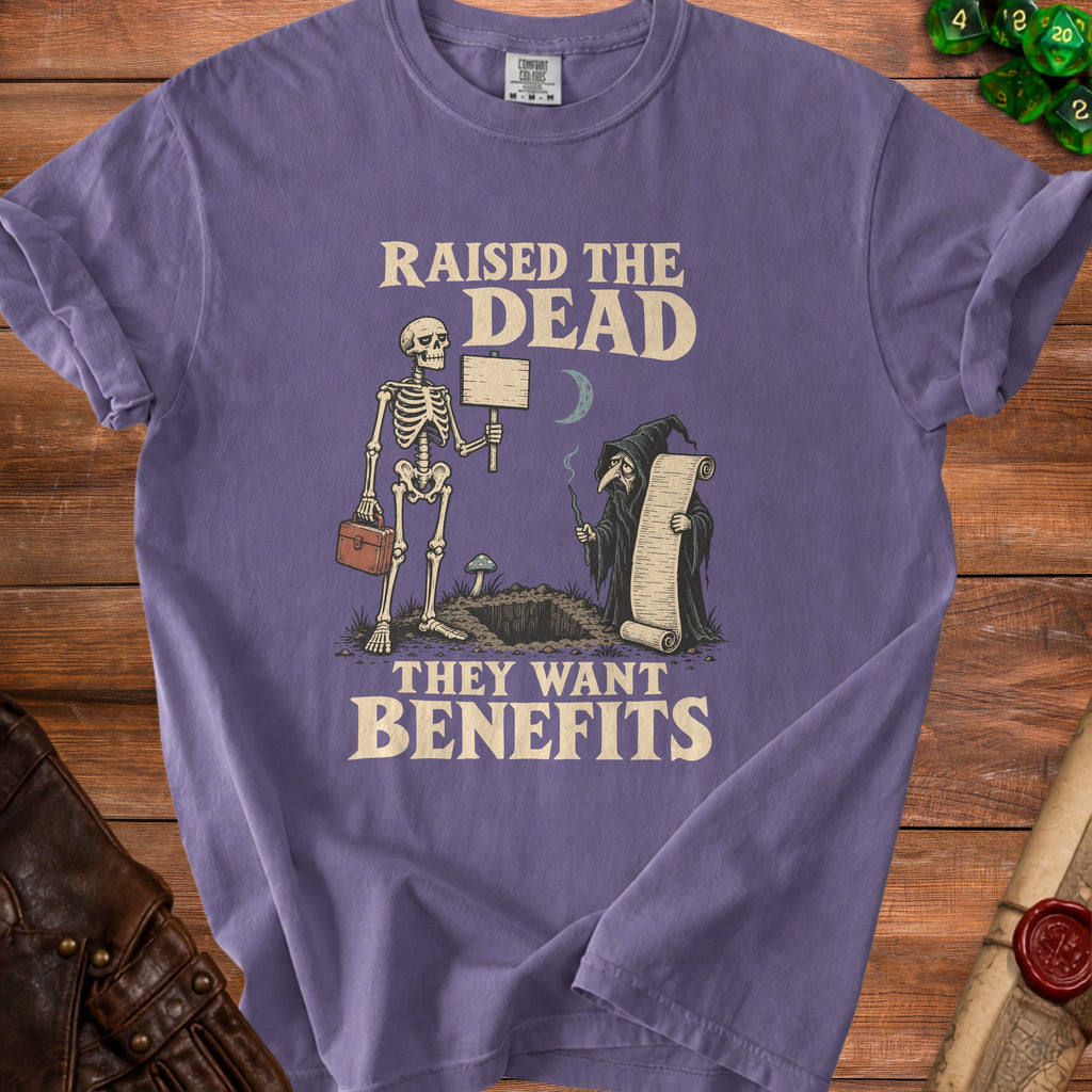 Purple t-shirt with skeleton and grim reaper graphic and text: "Raised the Dead, They Want Benefits."