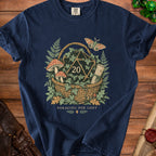 Navy t-shirt with foraging basket graphic featuring a d20, mushrooms, moth, and scroll.