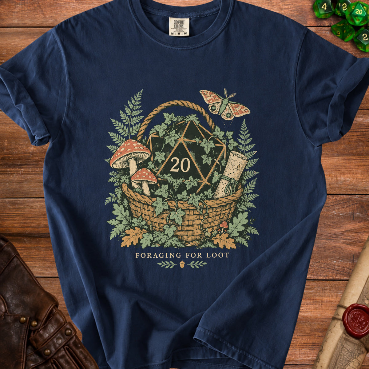 Navy t-shirt with foraging basket graphic featuring a d20, mushrooms, moth, and scroll.