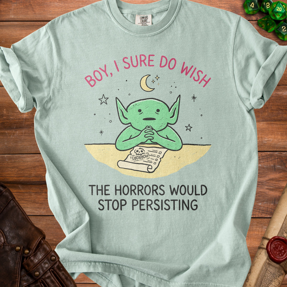 Light green t-shirt with cartoon goblin wishing "Boy, I sure do wish the horrors would stop persisting."