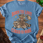 Blue t-shirt with goblin riding raccoon graphic and text "BORN TO LOOT CURSED TO WORK".