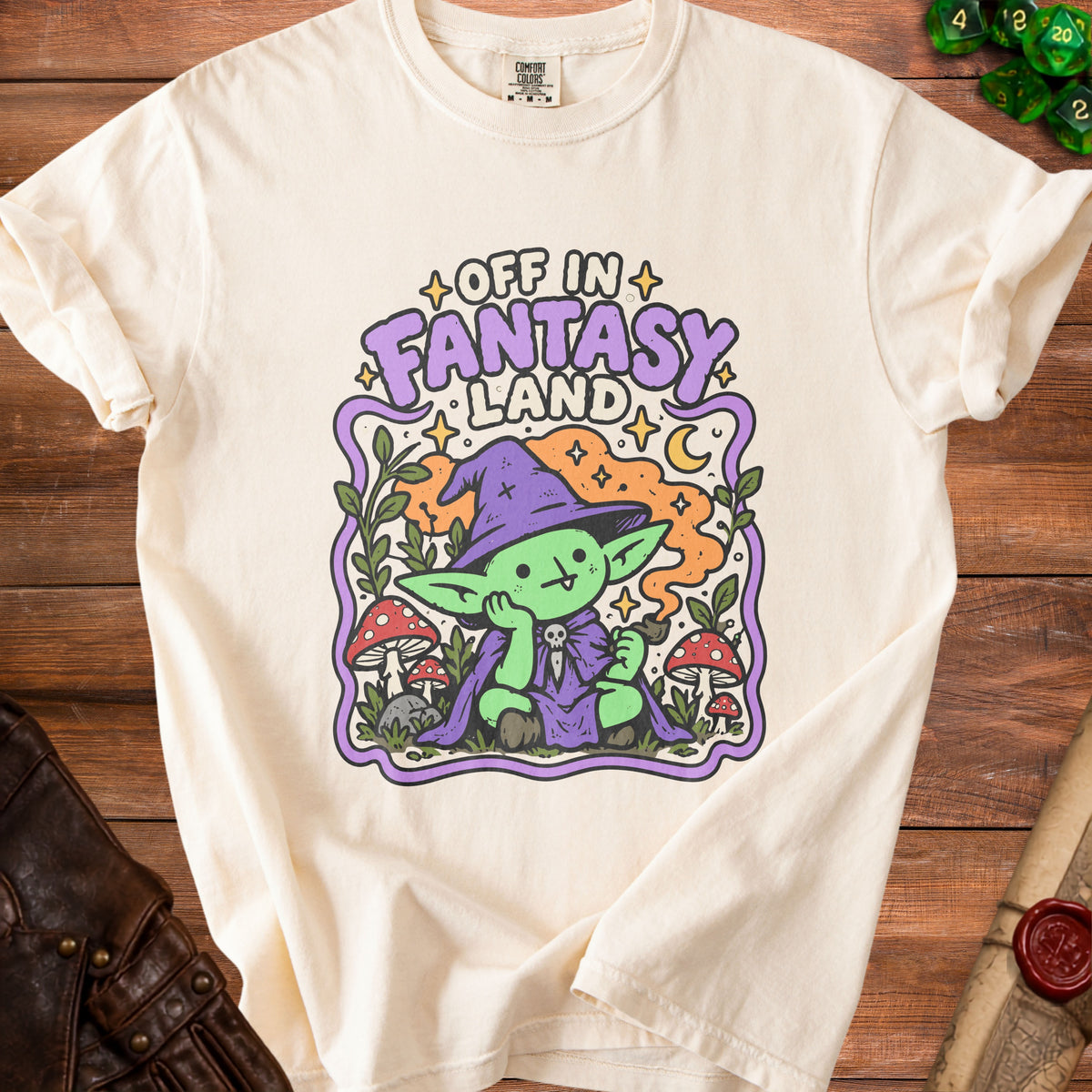 Cream t-shirt with green goblin character and "Off in Fantasy Land" text.
