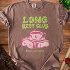 Brown t-shirt with "LONG REST CLUB" graphic and coffee cup, book, and sleep mask.
