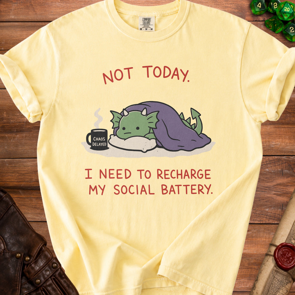 Yellow t-shirt with a cartoon dragon under a blanket and text "NOT TODAY. I NEED TO RECHARGE MY SOCIAL BATTERY."