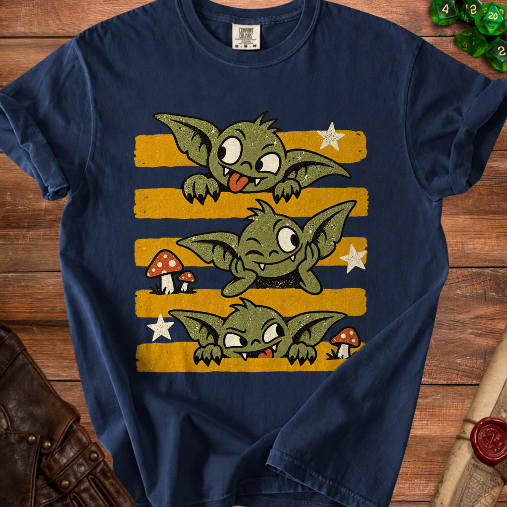 Three cartoon goblins peeking over yellow stripes on a navy t-shirt.